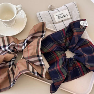 Plaid bow-tie scrunchie with button detail in Indigo and Camel colors.