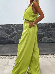 Yellow green wide-leg jumpsuit with floral applique straps and blouson waist.