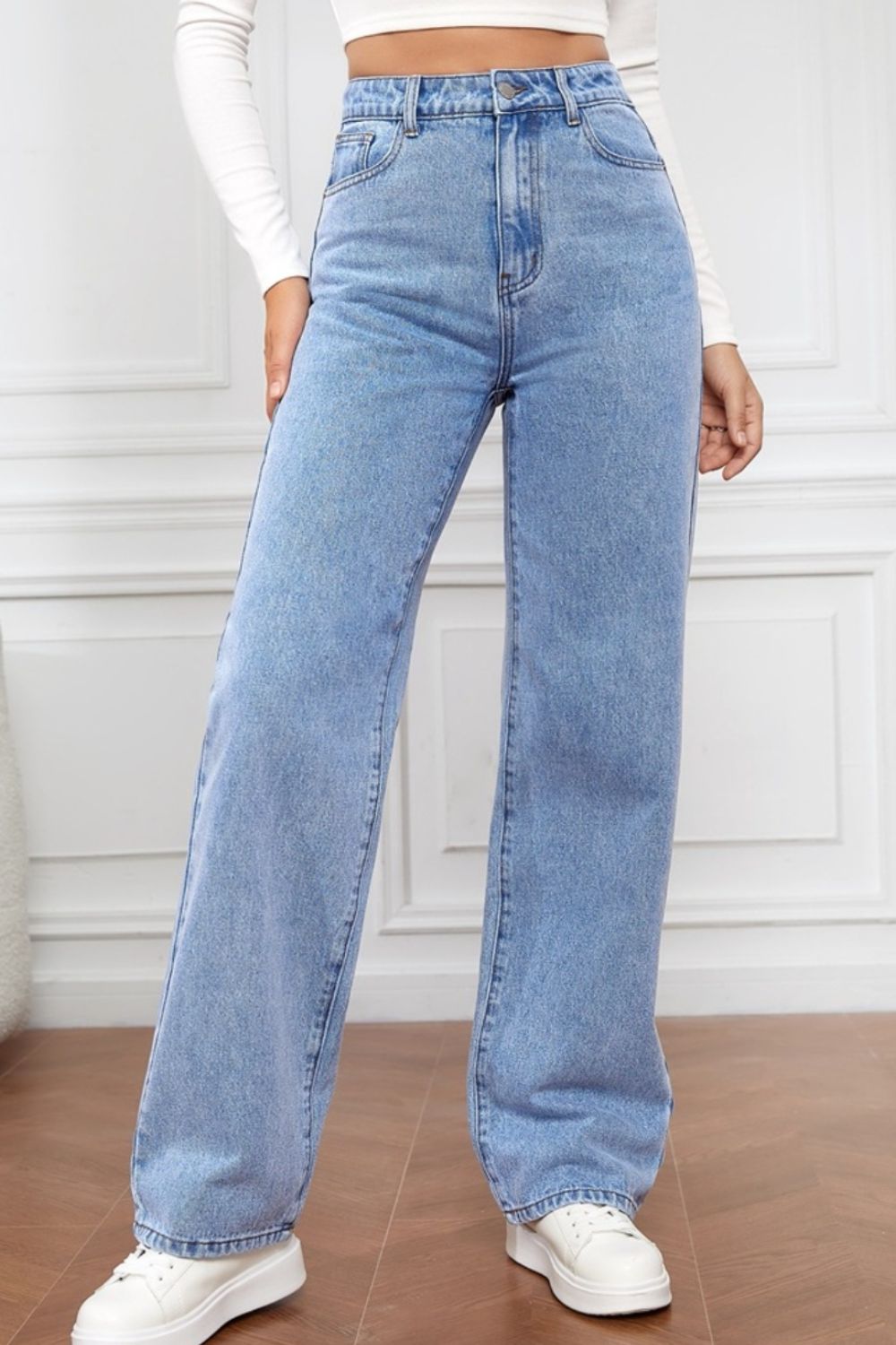 Light blue denim wide-leg jeans with a sculpted waist and button fly.