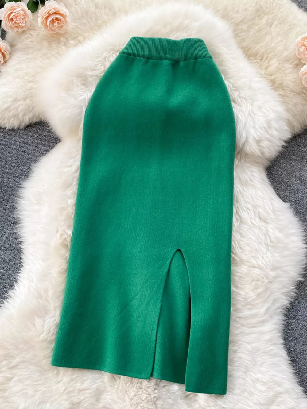 Green knit midi skirt with a high waist and side slit detail.