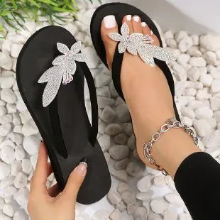 Black thong sandals with crystal flower embellishments and a platform sole.