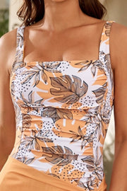 Floral ruched square neck swimsuit in orange and white with leaf print and ruching detail.