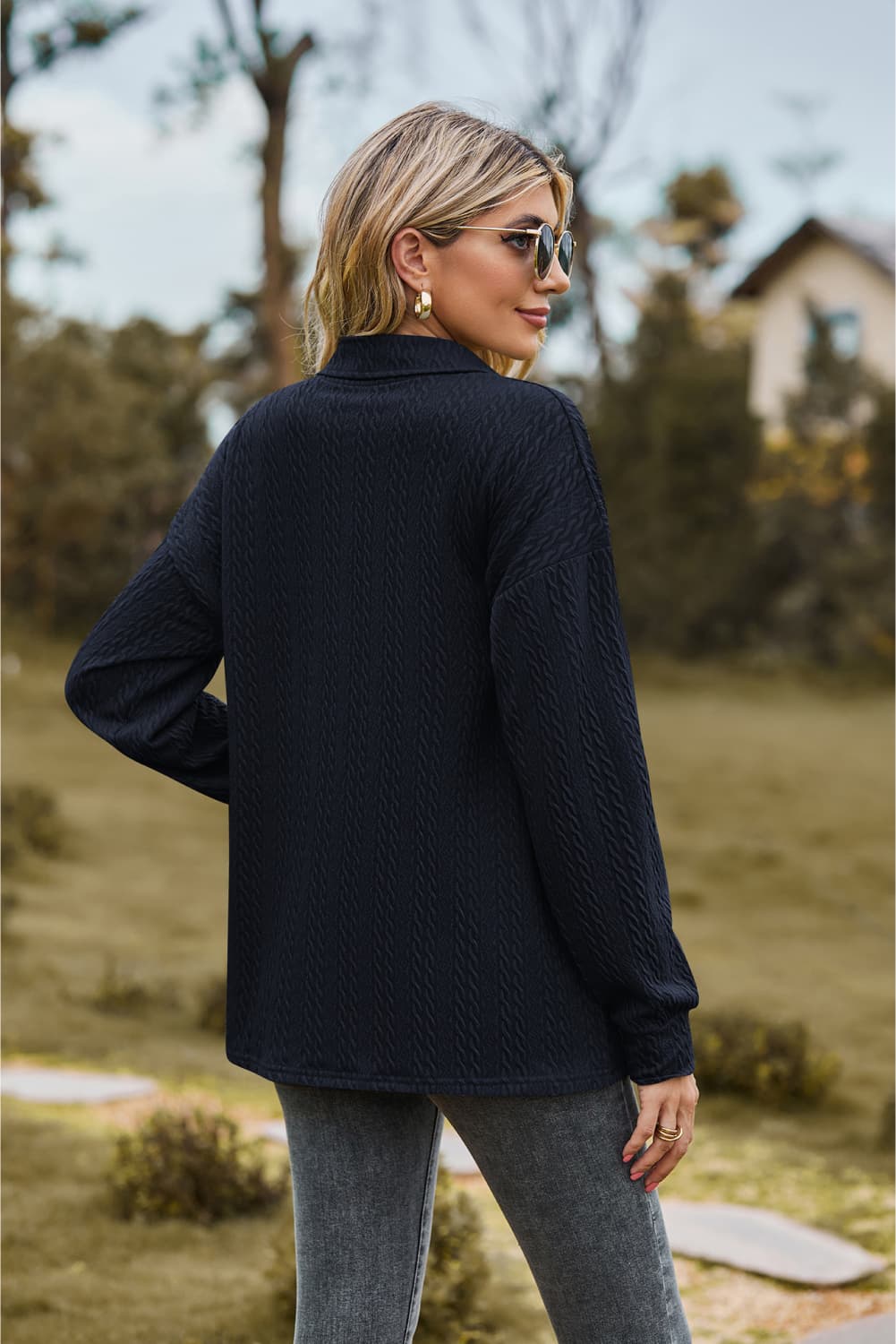 Dark blue textured knit polo shirt with long sleeves and a collared neckline.