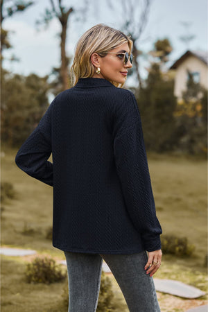 Dark blue textured knit polo shirt with long sleeves and a collared neckline.