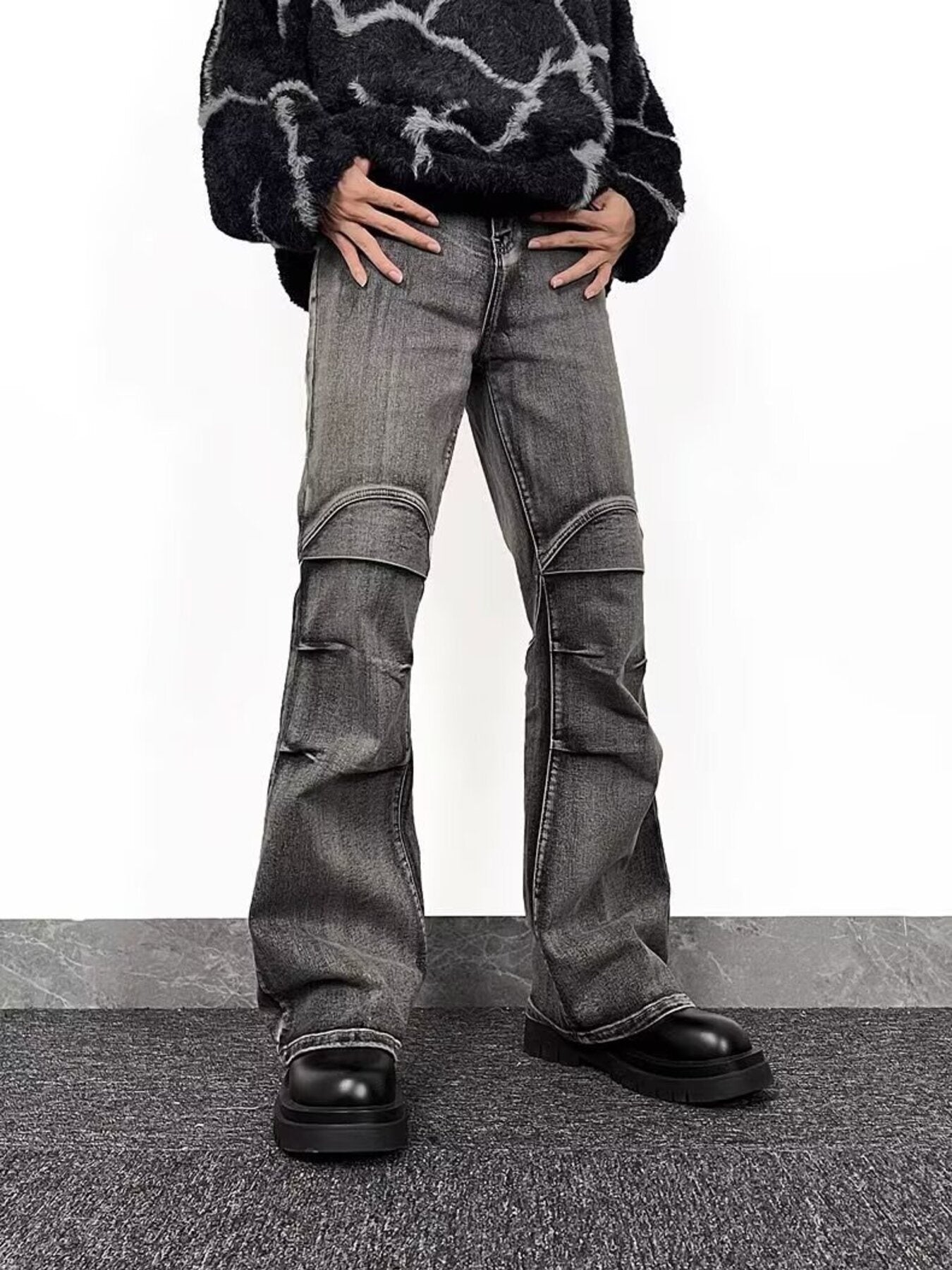 Men's relaxed fit washed grey flare jeans with distressed details and paneling.