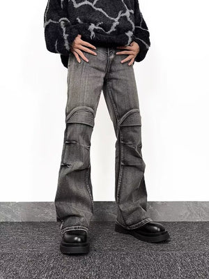Men's relaxed fit washed grey flare jeans with distressed details and paneling.