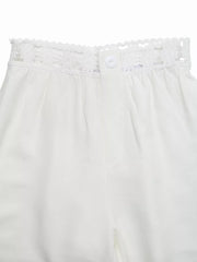 White wide-leg pants with crochet waistband detail and button closure.