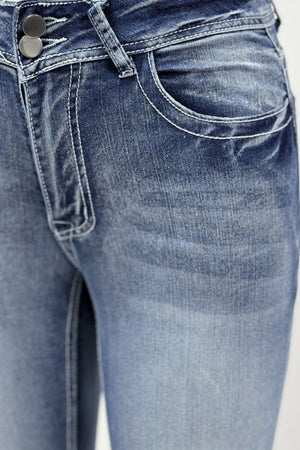 Light wash bootcut jeans with double button closure and white contrast stitching.