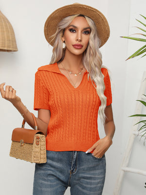 Orange cable knit polo top with short sleeves and a collared neckline.