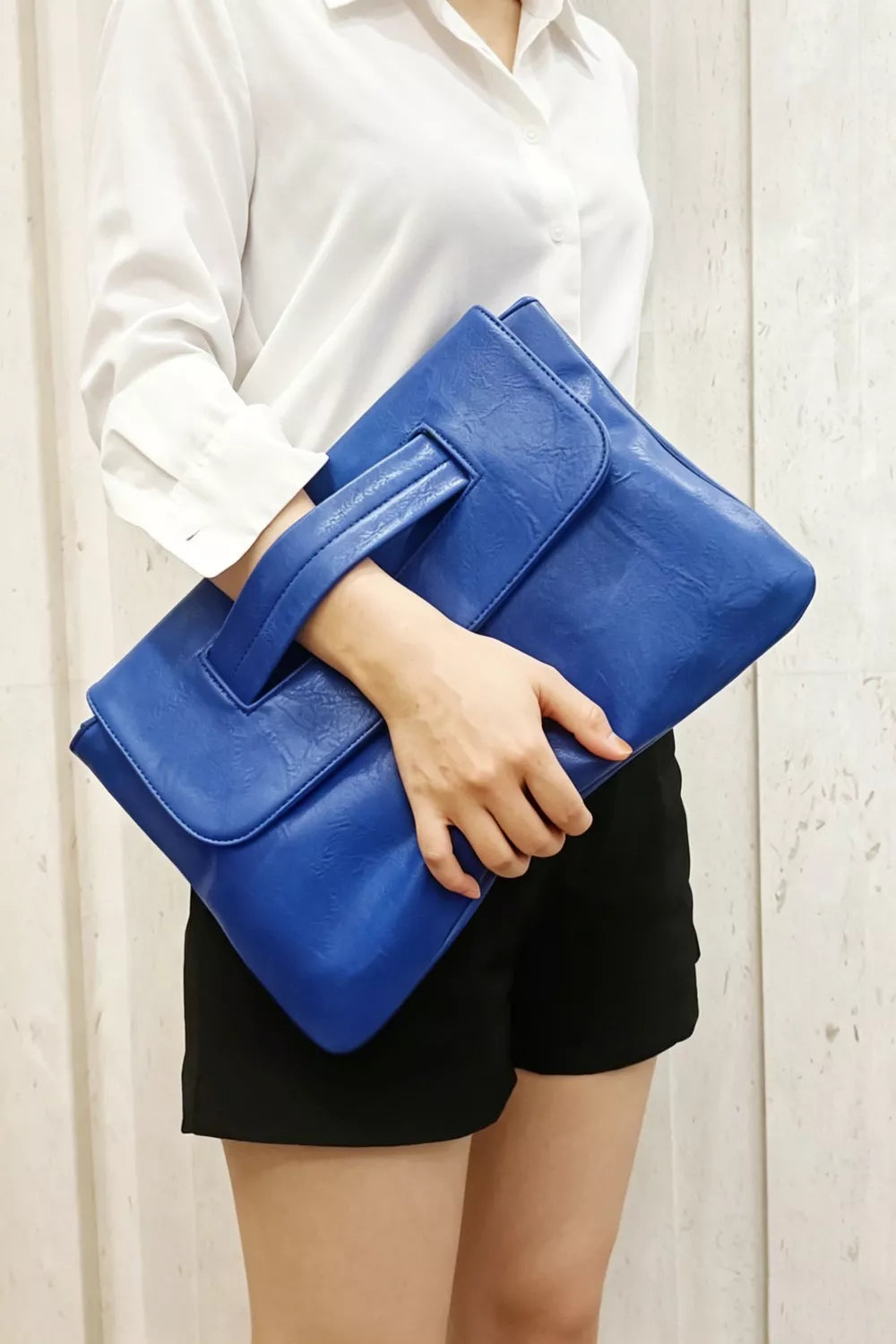 Blue distressed leather envelope clutch with cut-out handle