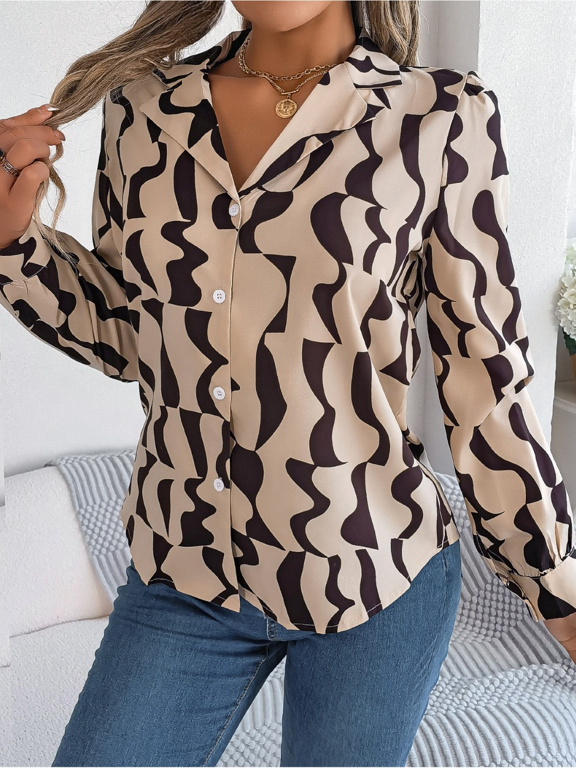 Tan abstract wave print silk-touch blouse with button front and collar.