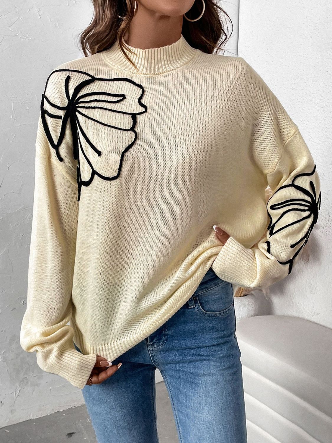 Pastel yellow acrylic knit sweater with embroidered floral motifs on the chest and sleeve.