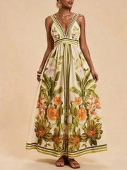Tropical leaf print maxi dress with deep V-neck and striped straps.