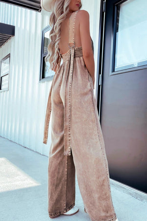 Khaki denim wide-leg jumpsuit with smocked waist and tie belt.