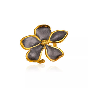 Lustrous floral open ring in gold with dark gray enamel petals and a textured gold center.