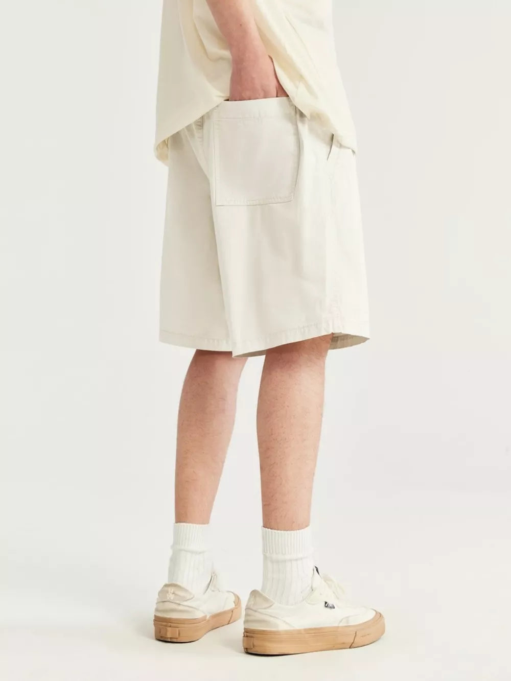 Men's ivory chino shorts with drawstring and back pocket detail.