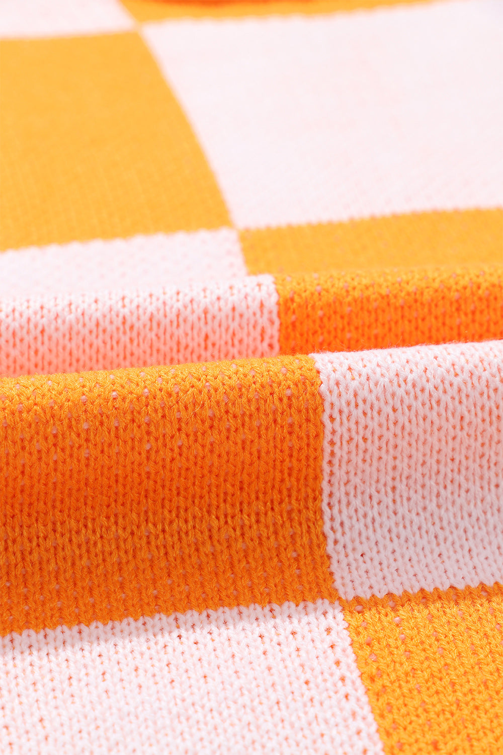 Checkerboard knit sweater in tangerine and white acrylic with a relaxed fit.