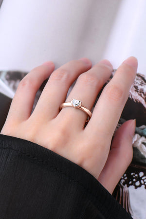 Rose gold ring with a heart-cut moissanite solitaire on a sterling silver band.