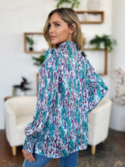 High neck abstract print blouse in blue and violet with long sleeves.