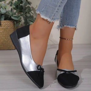 Black and silver slip-on flats with bow detail and wedge heel.