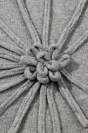 Gray knit blouse with a central embroidered bloom detail and ribbed texture.