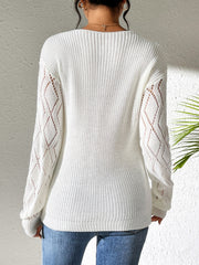 White openwork knit sweater with diamond lace sleeves and a ribbed hem.