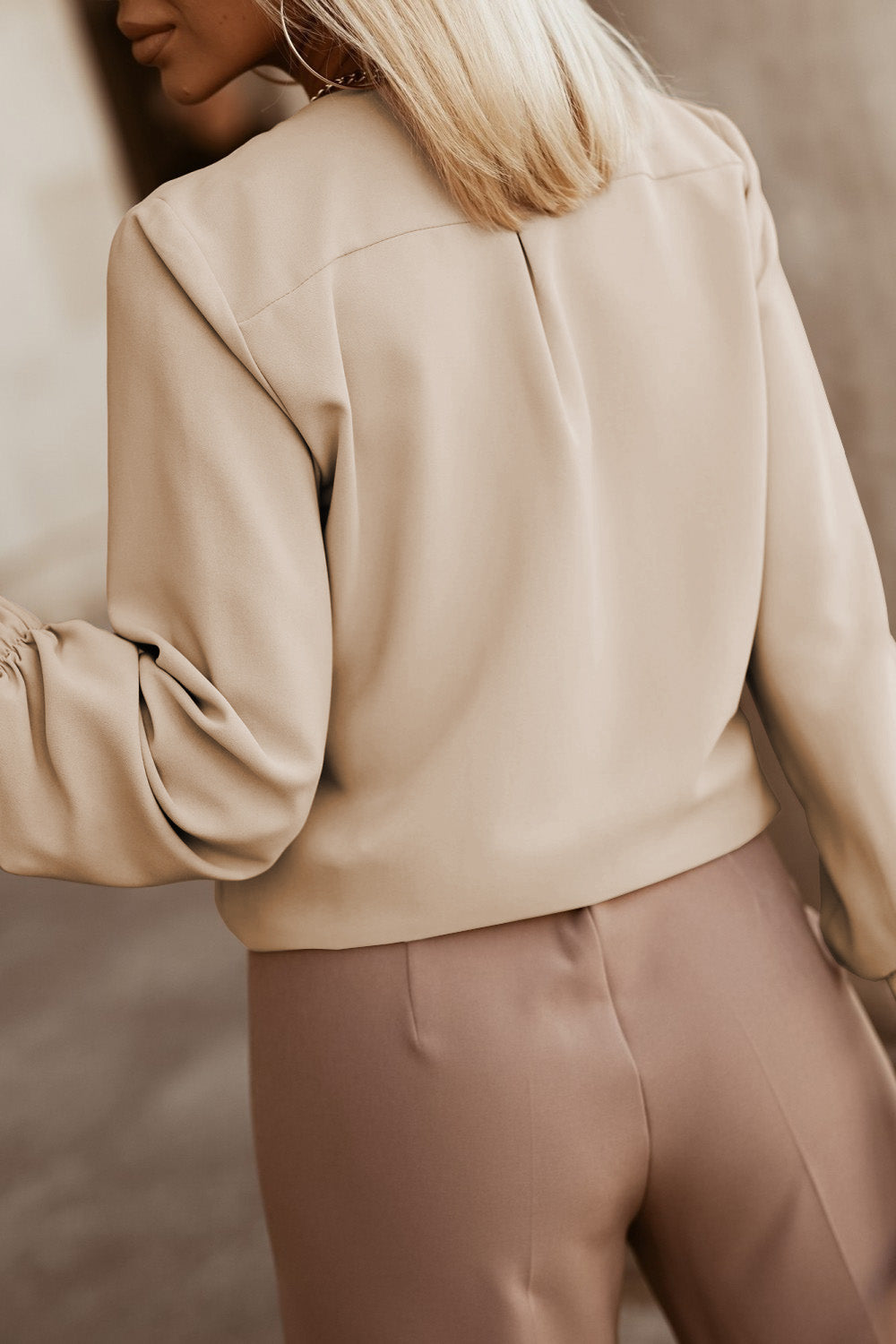 Khaki pleated yoke blouse with button detail and gathered sleeves.