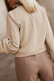 Khaki pleated yoke blouse with button detail and gathered sleeves.