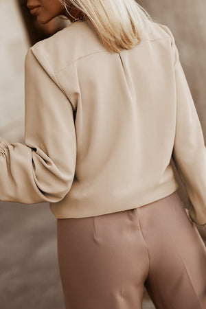 Khaki pleated yoke blouse with button detail and gathered sleeves.