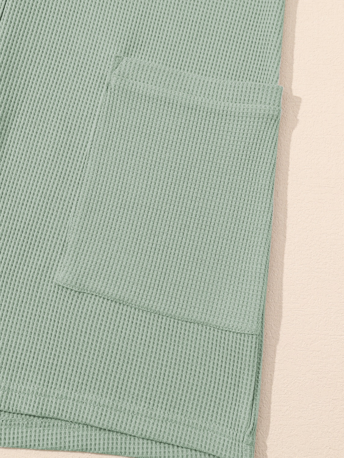 Sage waffle knit button-down romper with a chest pocket detail.