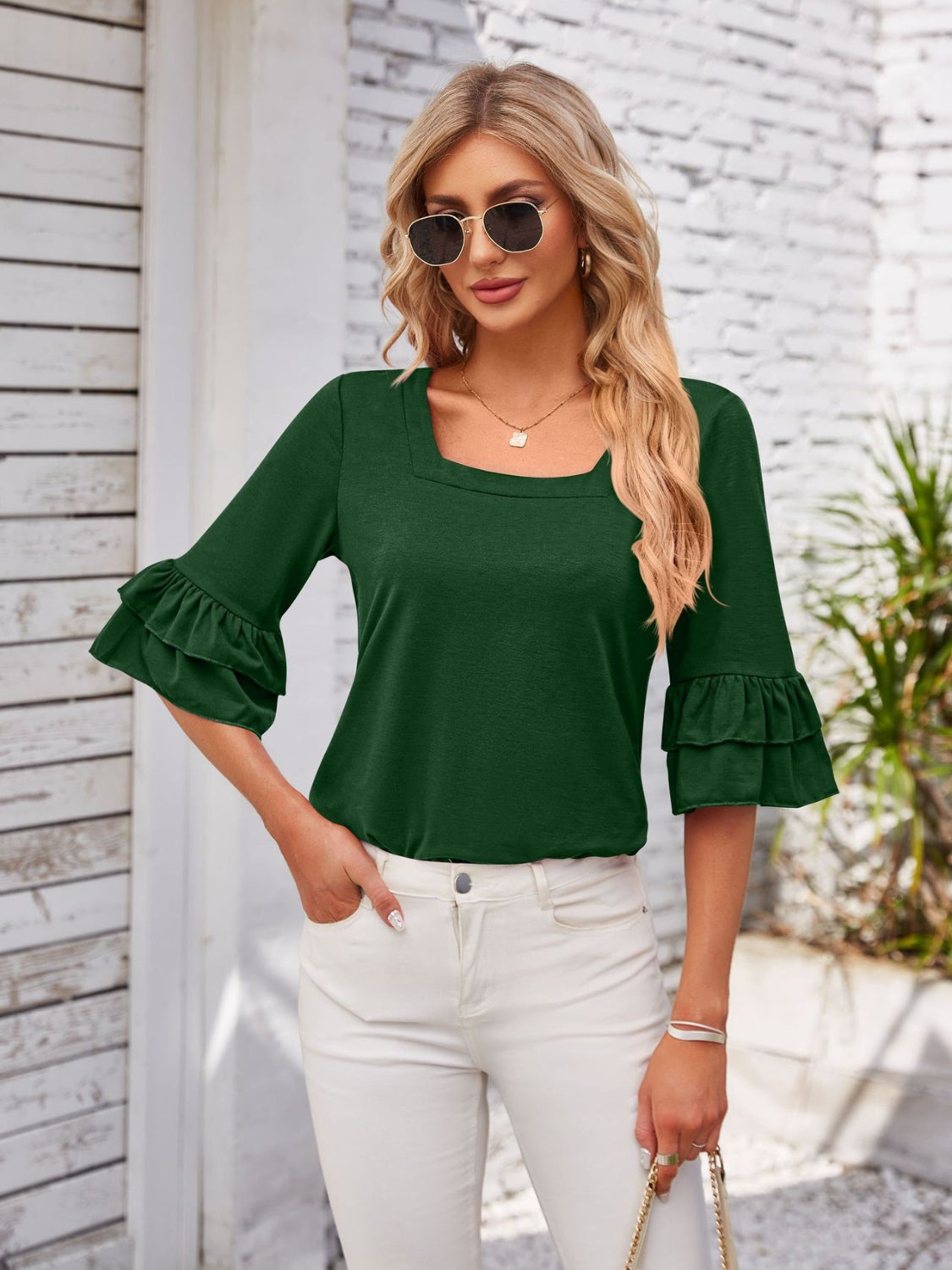 Dark green blouse with square neckline and ruffled bell sleeves.