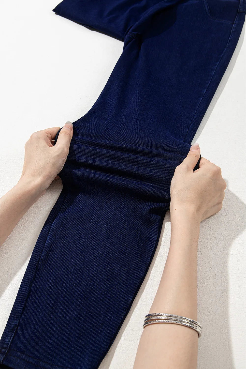 Dark denim jeggings with faux pockets, showing stretch fabric detail.