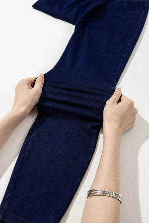 Dark denim jeggings with faux pockets, showing stretch fabric detail.