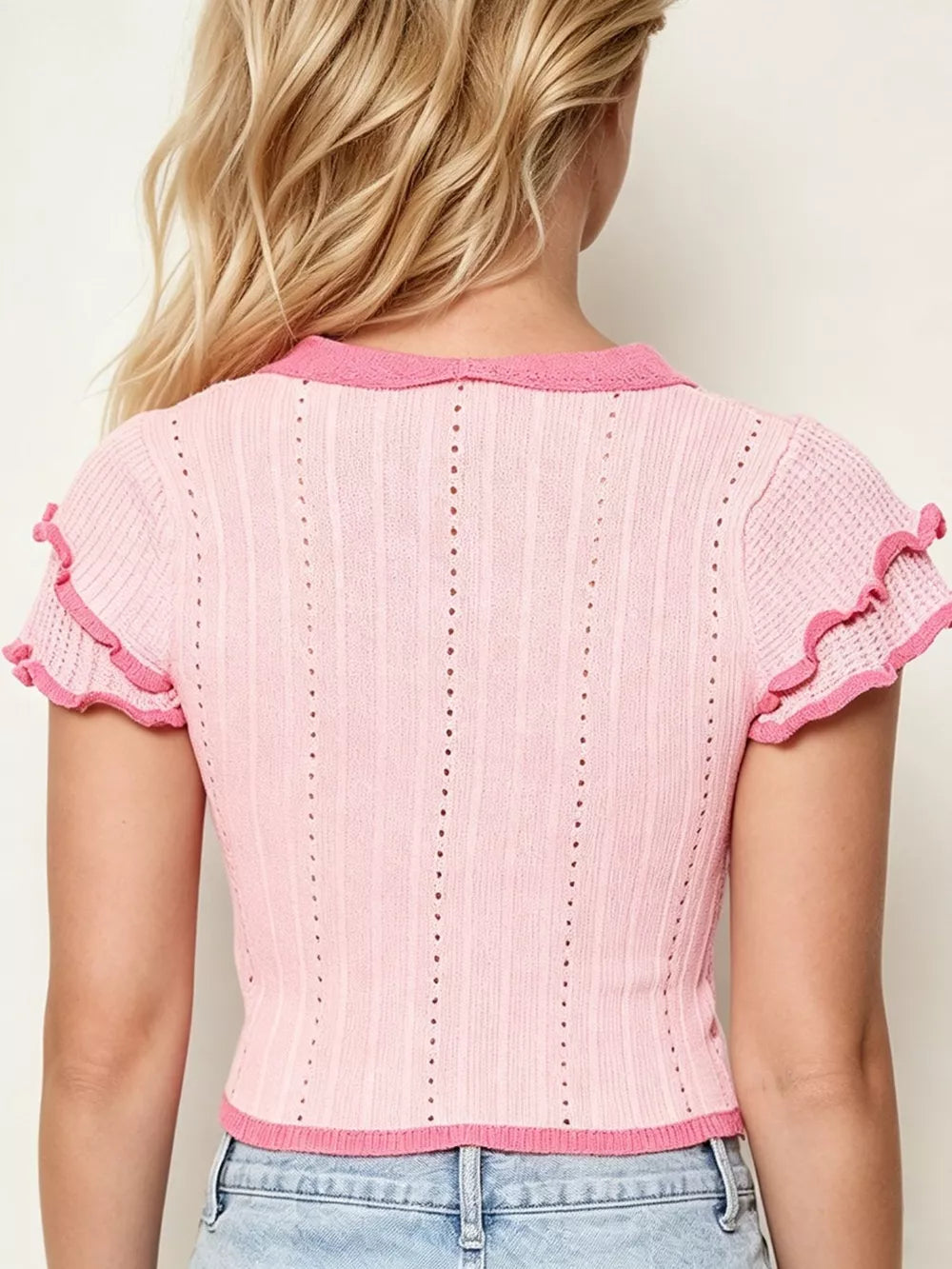 Pink knit maternity t-shirt with frill collar and sleeves, ribbed texture, and eyelet details.