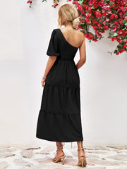 Black one-shoulder tiered midi dress with smocked bodice and puff sleeve.