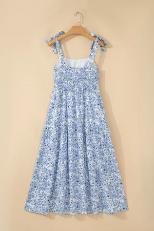 Maxi dress with blue floral print, smocked bodice, and tie shoulder straps.