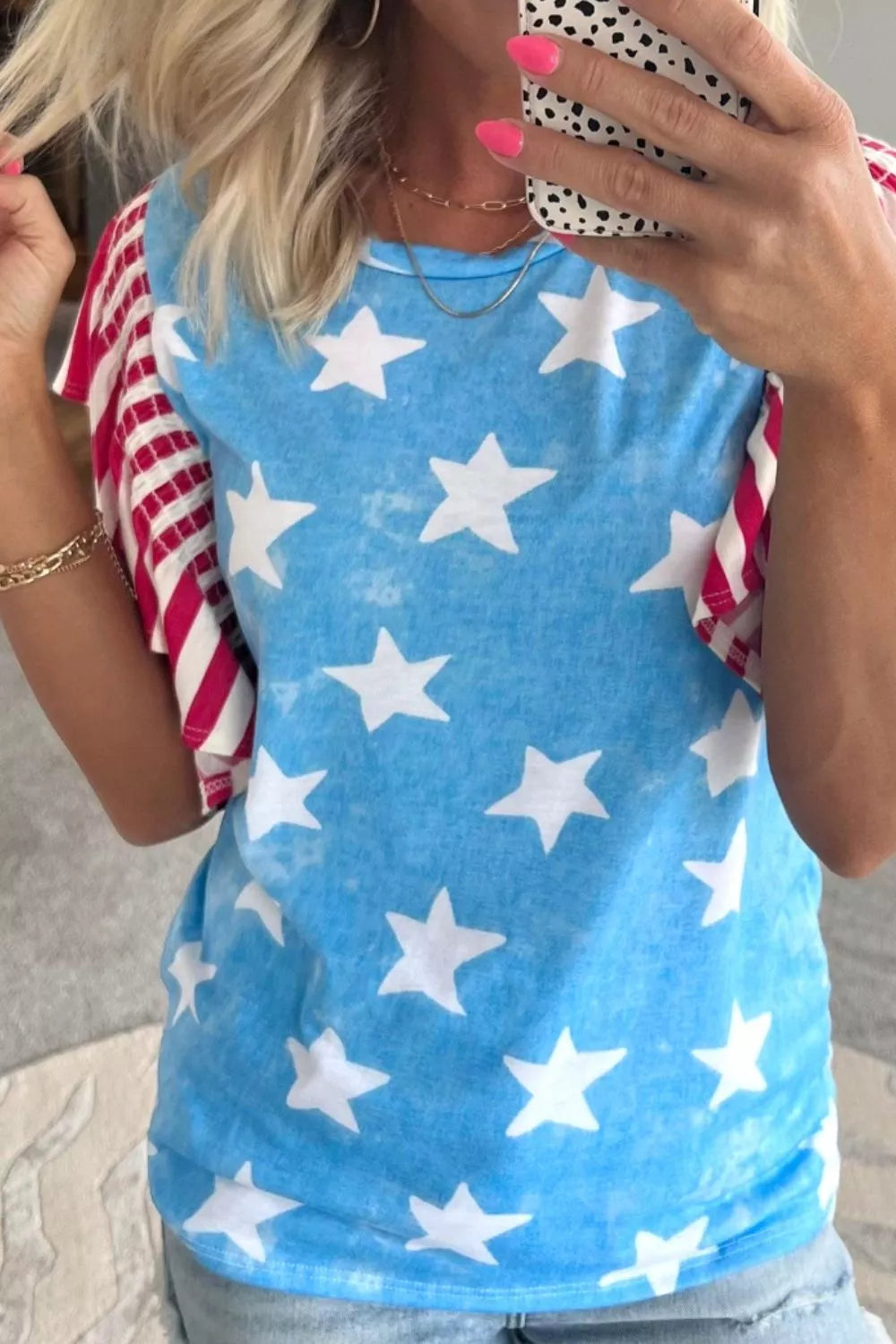 Patriotic t-shirt with blue star print and red striped ruffle sleeves.