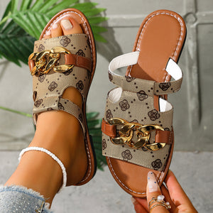 Patterned slide sandals in apricot with chain accent and brown trim.