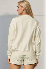 Cream knit crewneck sweater with long sleeves and ribbed trim, 100% polyester.