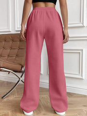 Pleated palazzo drawstring trousers in dusty pink with a wide leg and elastic waist.