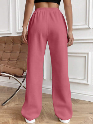 Pleated palazzo drawstring trousers in dusty pink with a wide leg and elastic waist.