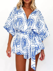 Blue celestial print wrap romper with short sleeves and tie waist.