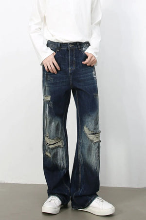 Oversized distressed dark wash denim jeans with wide legs and ripped details.