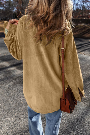 Camel corduroy overshirt with button cuffs and relaxed fit, styled with jeans.