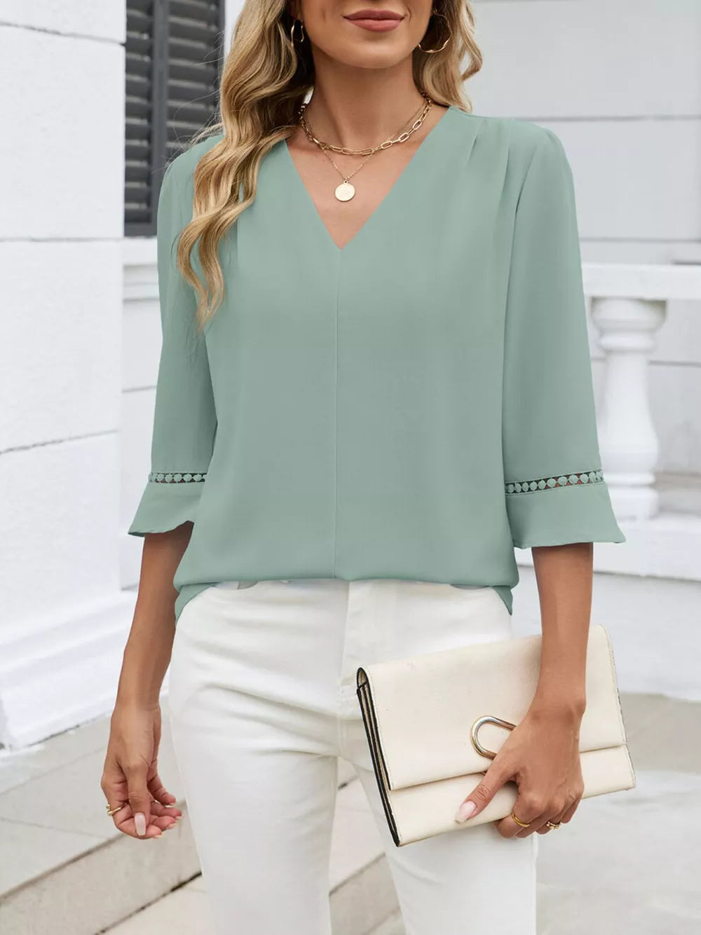 Sky blue V-neck blouse with 3/4 sleeves featuring lace embellishments at the cuffs.