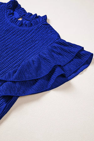 Blue textured short sleeve shirt with ruffle trim on neckline and sleeves.