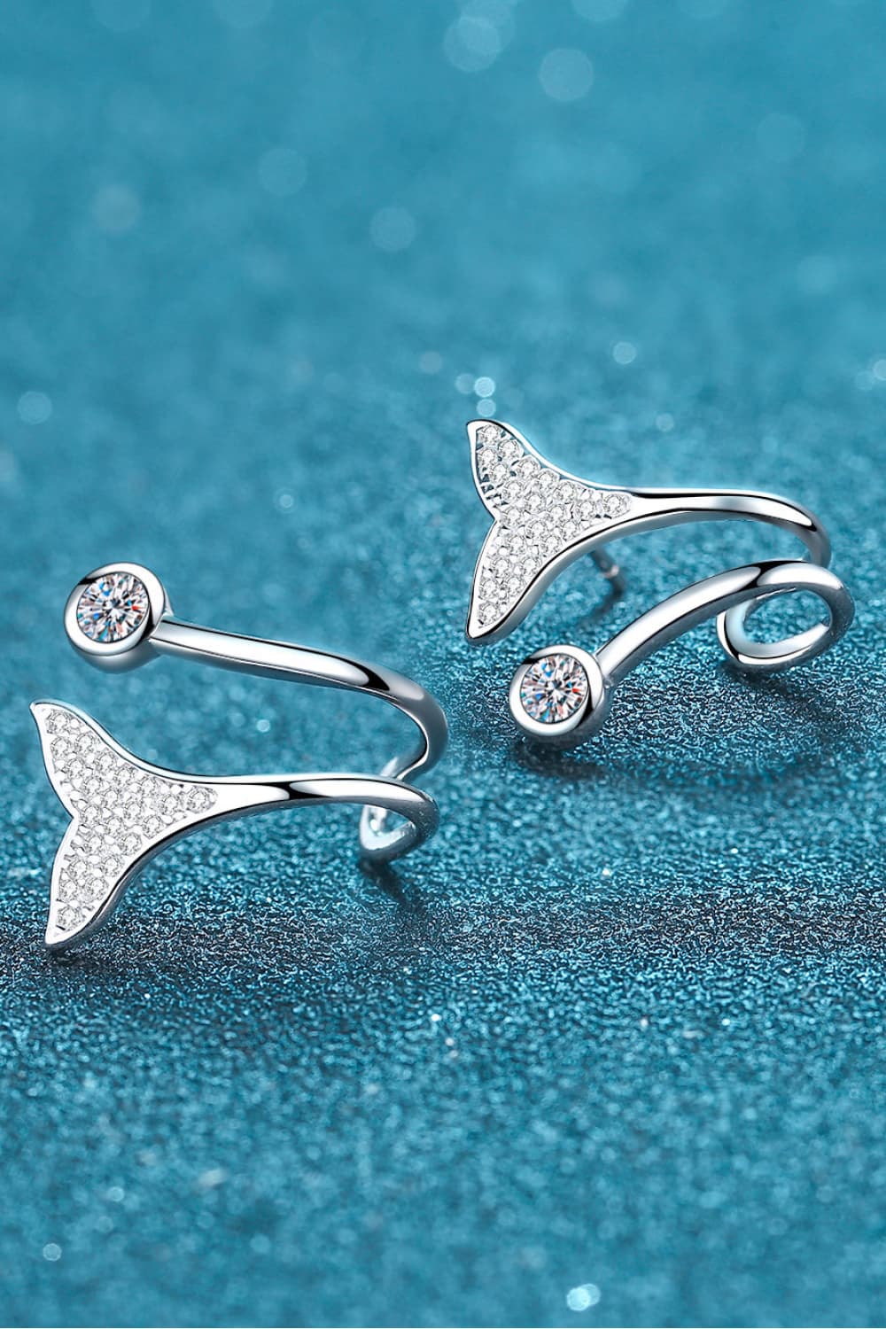 Silver stud earrings with crystal-embellished mermaid tails and round crystal accents.