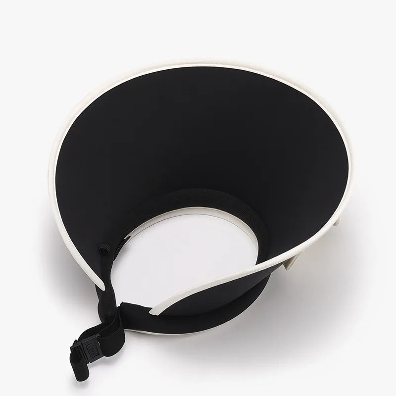 Black sun visor with white contrast trim and adjustable strap.
