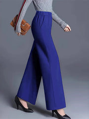Blue high-waisted wide leg cotton trousers with pockets, styled with a grey sweater and black heels.
