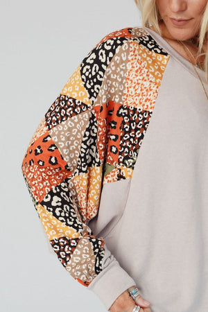 Patchwork raglan sleeve top in light gray with colorful animal print patchwork sleeves.